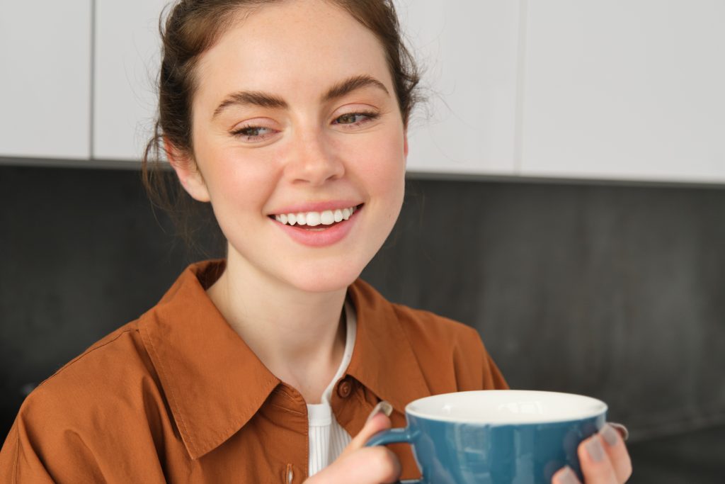 Femme qui sourit avec une tasse